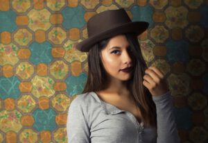 Kobieta ubrana w stylu retro na tle kolorowej ściany